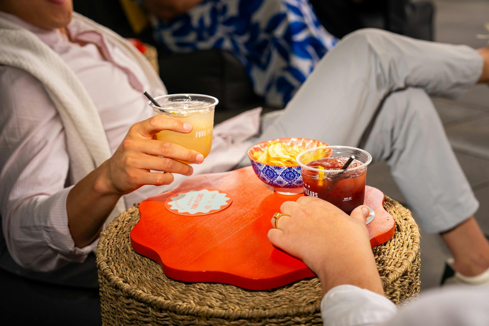 Two friends sitting in bean bags enjoying a cocktail