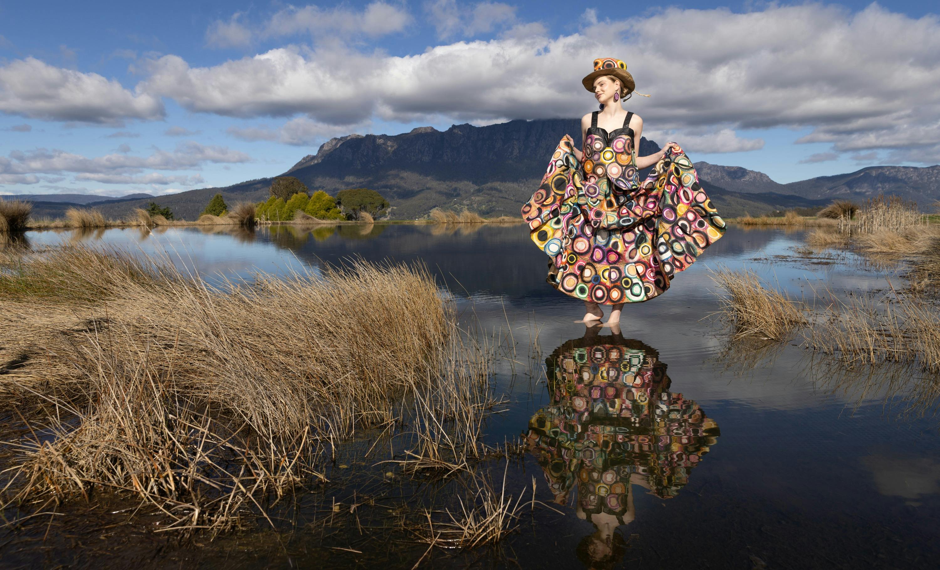Model in dress featuring circles standing in a pool in the Tasmanian Wilderness
