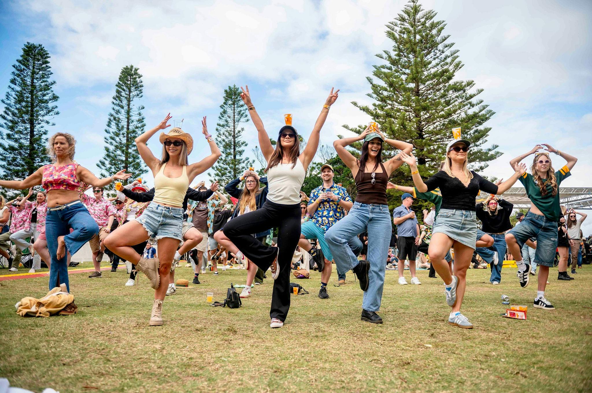 A group of people at Crafted doing yoga poses with beers in their hands
