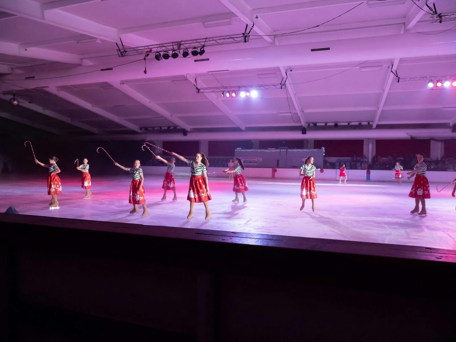 Figure skaters in Christmas costumes with candy canes.