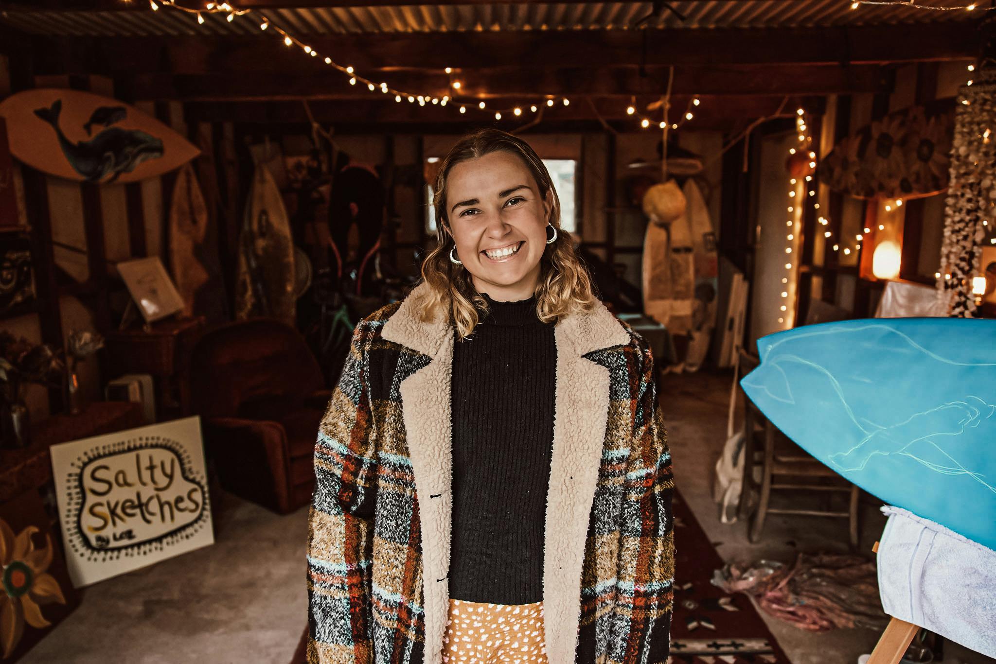 Young woman in a shed studio with fairy lights