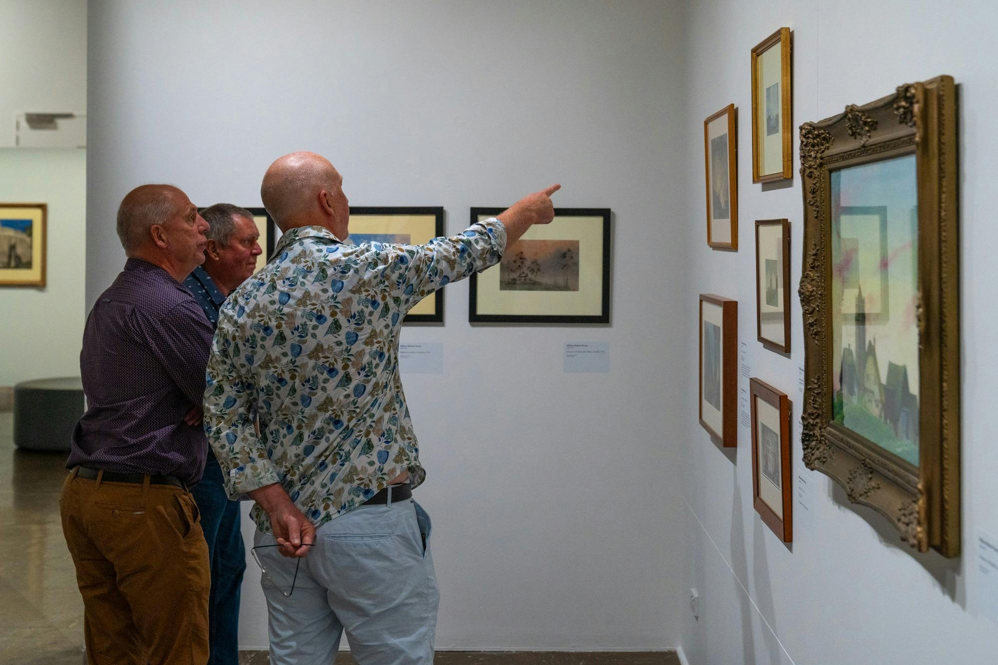 three men looking at an artwork in a Gallery