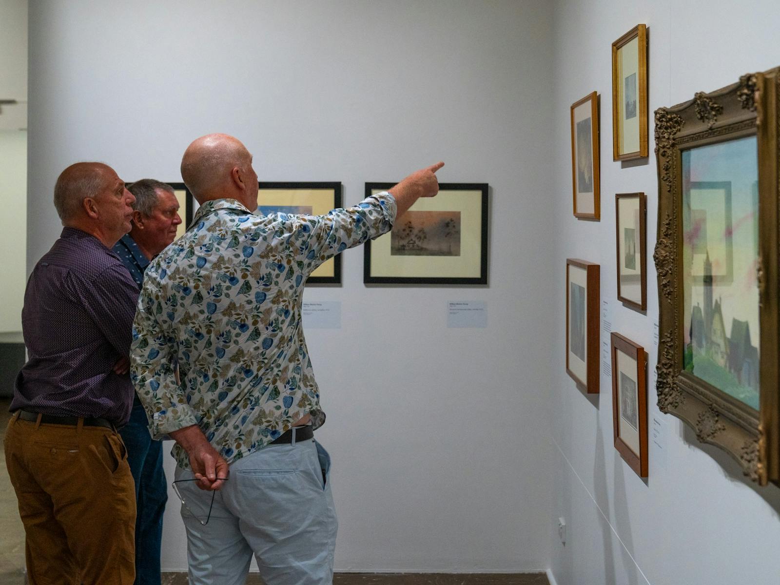 three men looking at an artwork in a Gallery