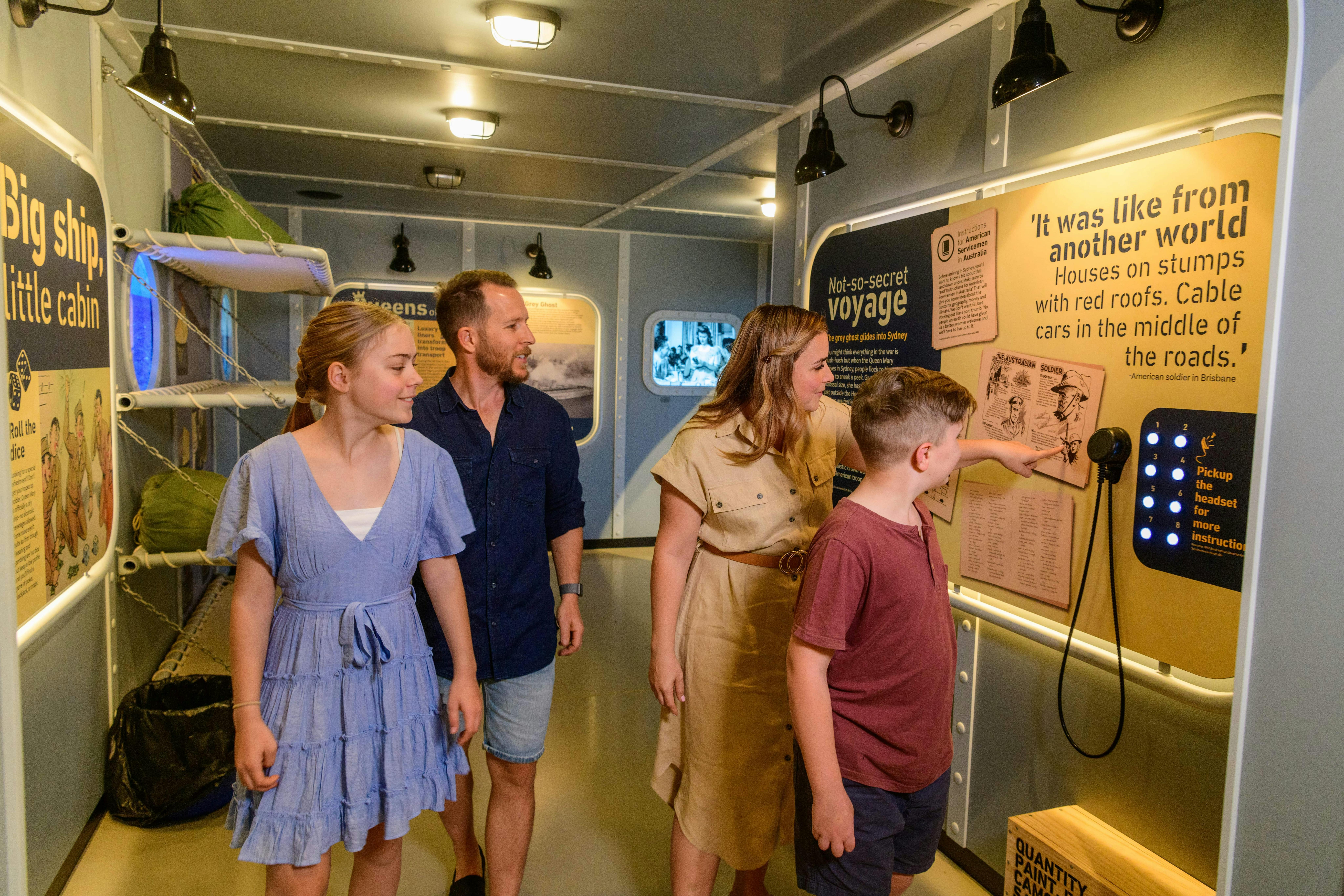 a family walking through an exhibit of the Queen Mary inside the Secret Base