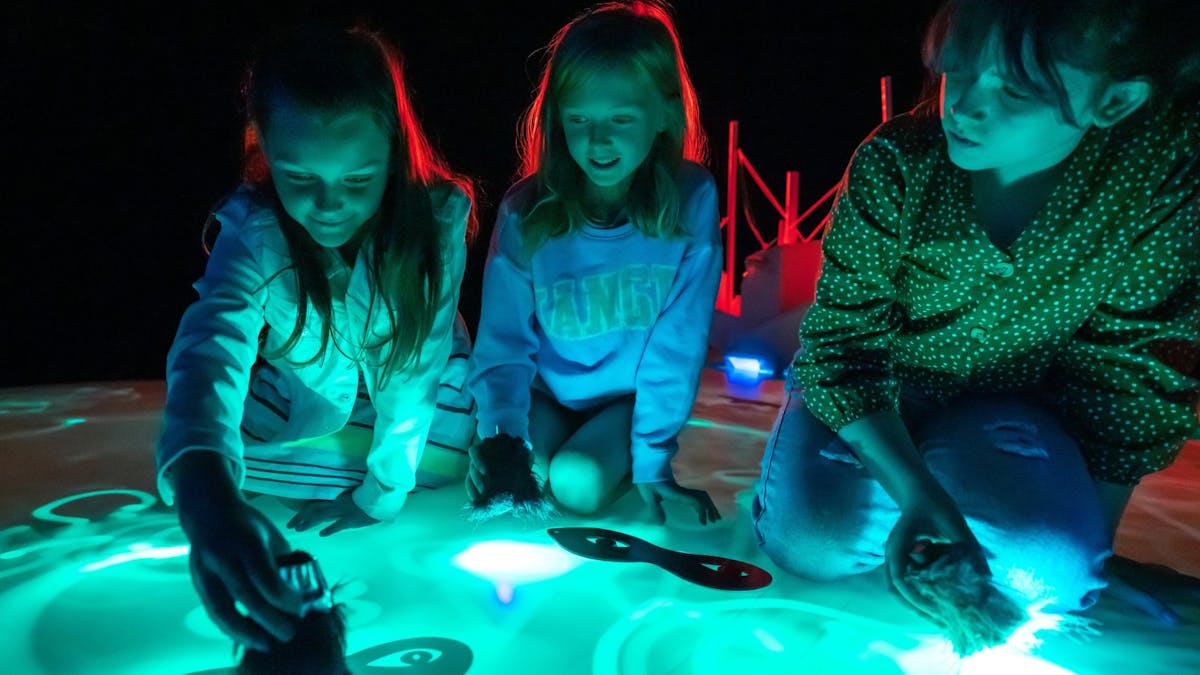 Young kids playing with light installations