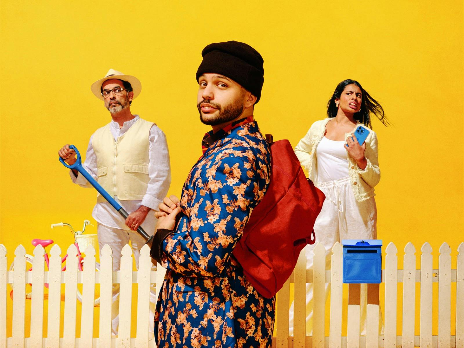 Three people stand against a bright yellow background