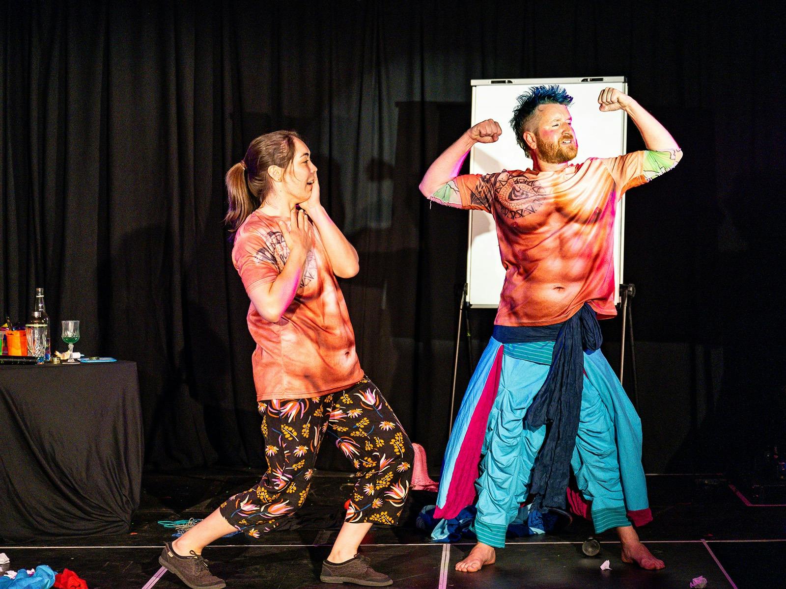 Woman laughing at man flexing wearing a muscle tshirt