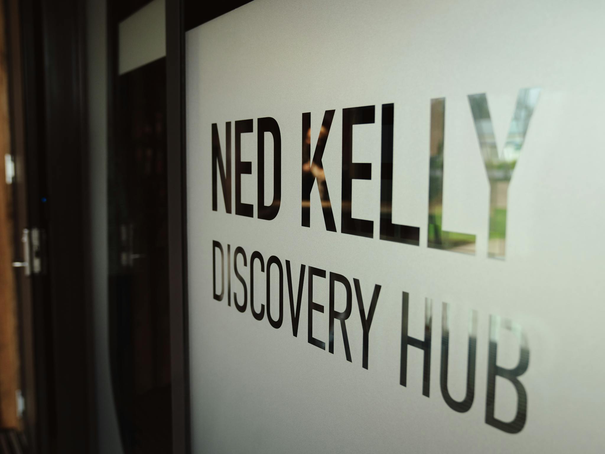 Frosted glass door with words Ned Kelly Discovery hub