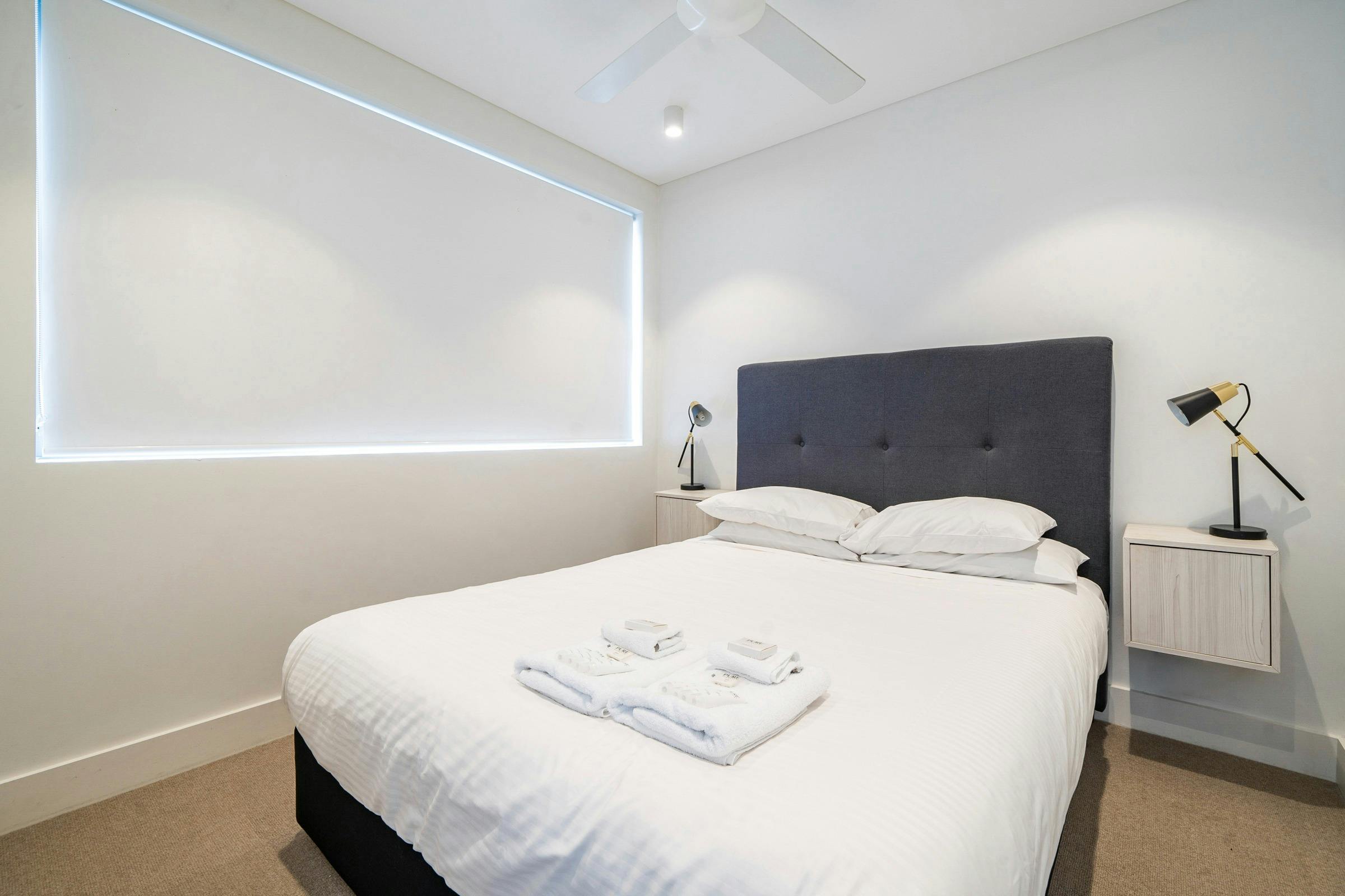 Modern bedroom with queen-sized bed and stylish furnishings in Bondi Beach apartment.