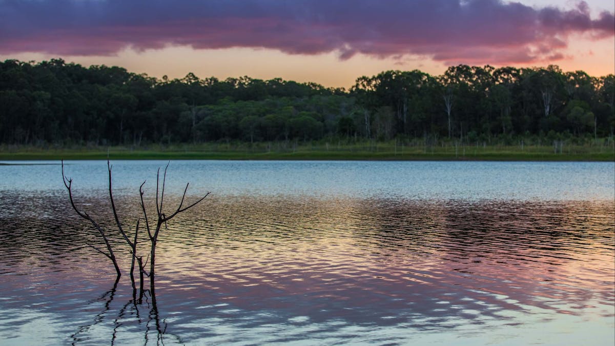 Purple and orange sunset with cloud reflection on lake water
