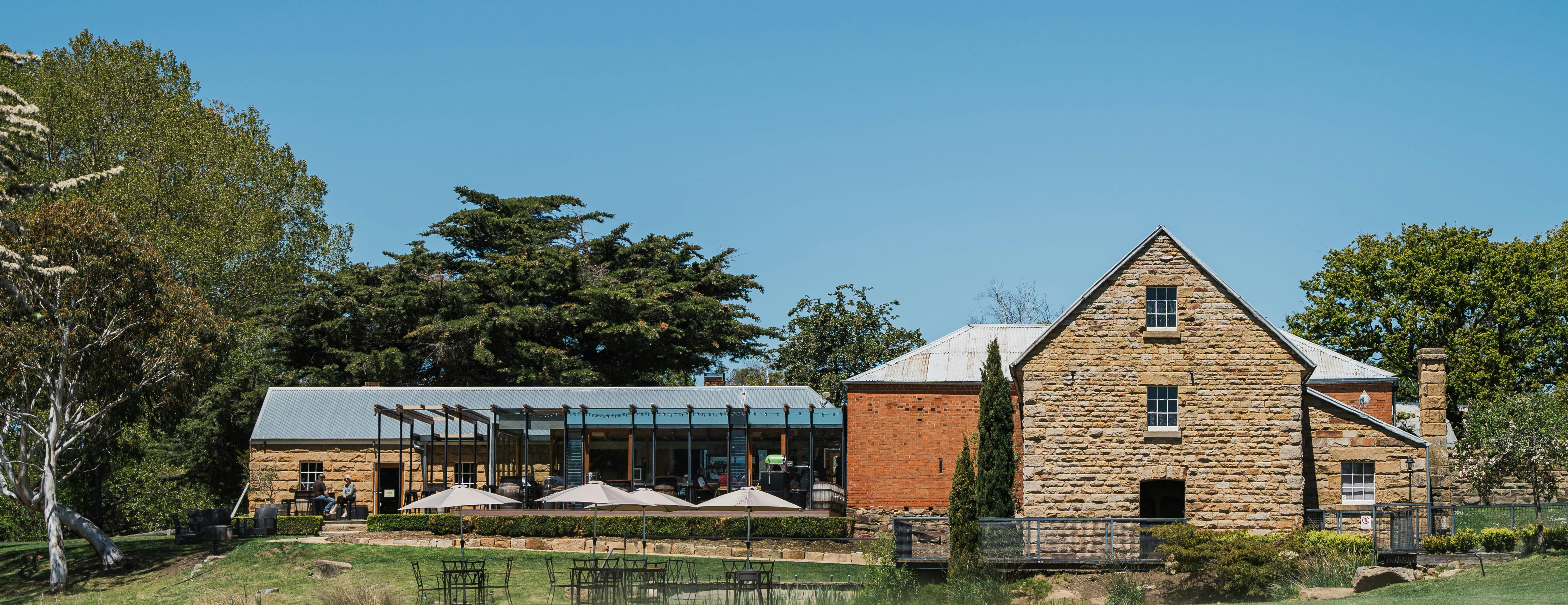 Long-table seafood dinner inside the historic Clyde Mill Distillery + Kitchen at Bothwell, featuring