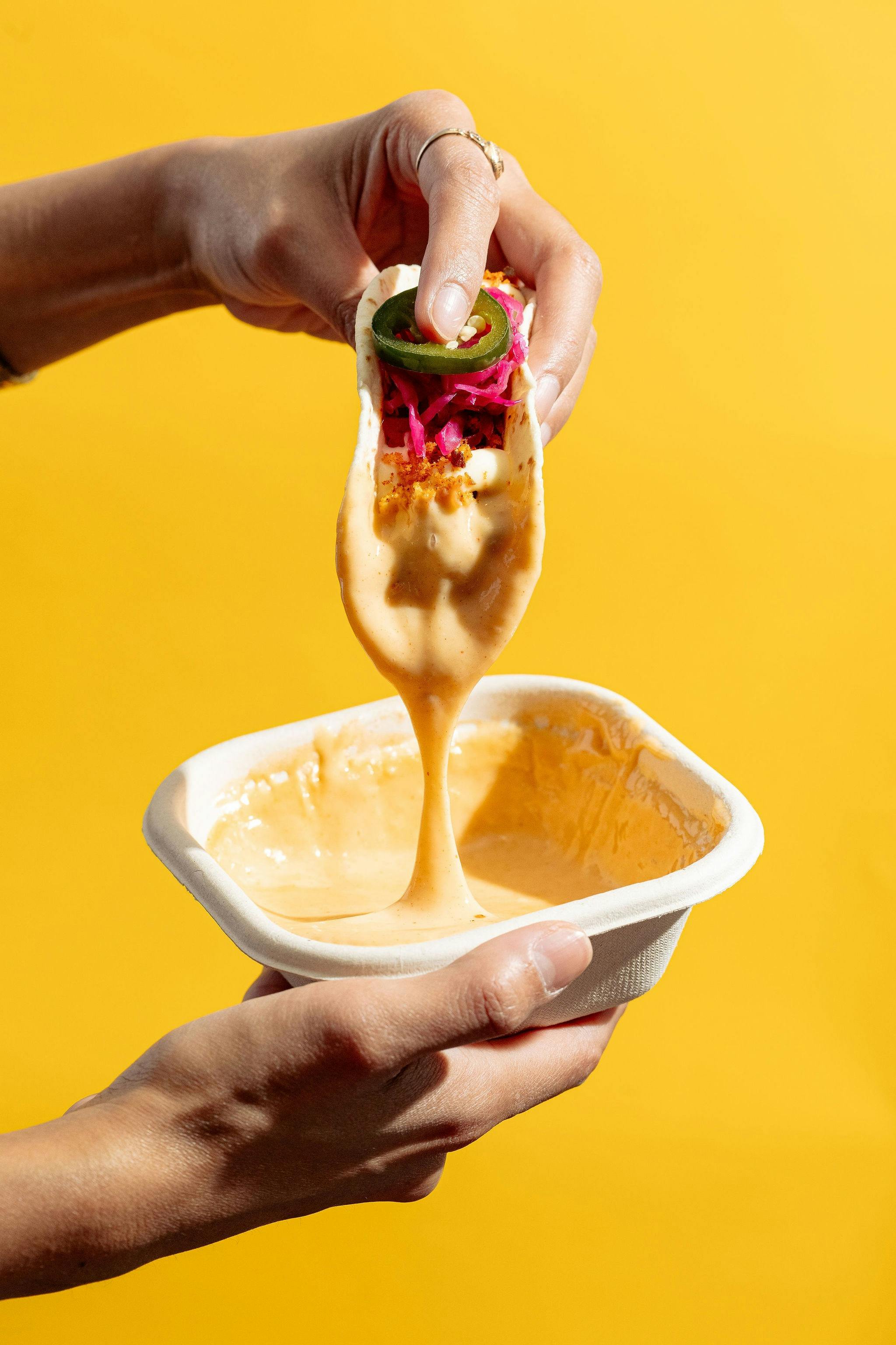 Tacos dipped in our house nachos cheese sauce