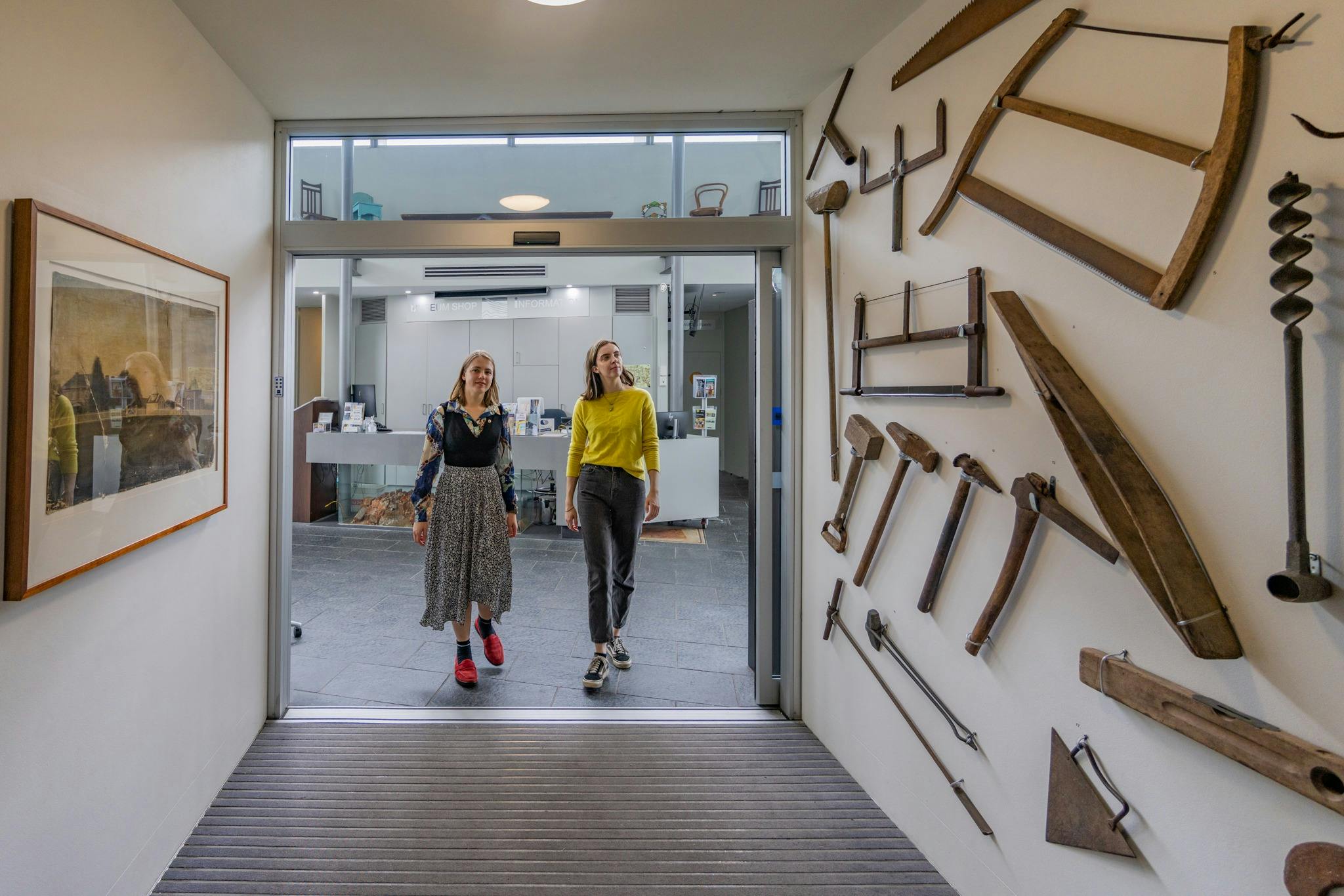 兩名婦女走進霍克斯伯里地區博物館，參觀古老的農具。
