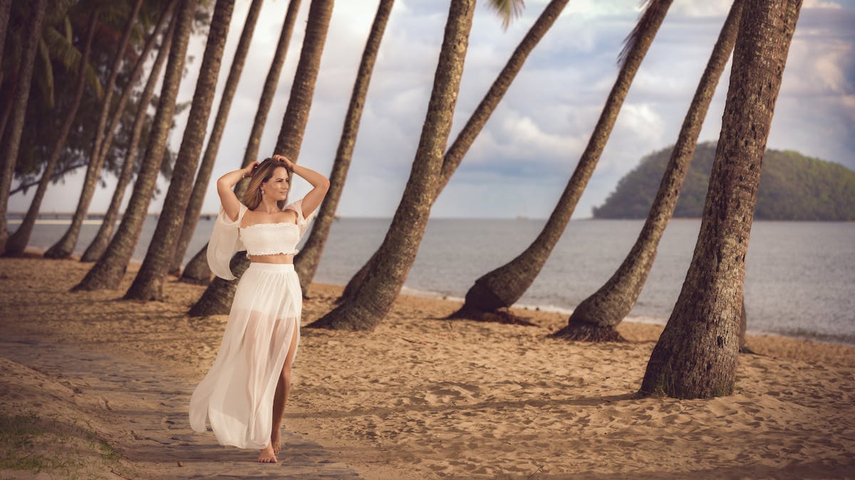 Holiday photography at Palm Cove Beach Queensland. A woman is walking under the palm trees.