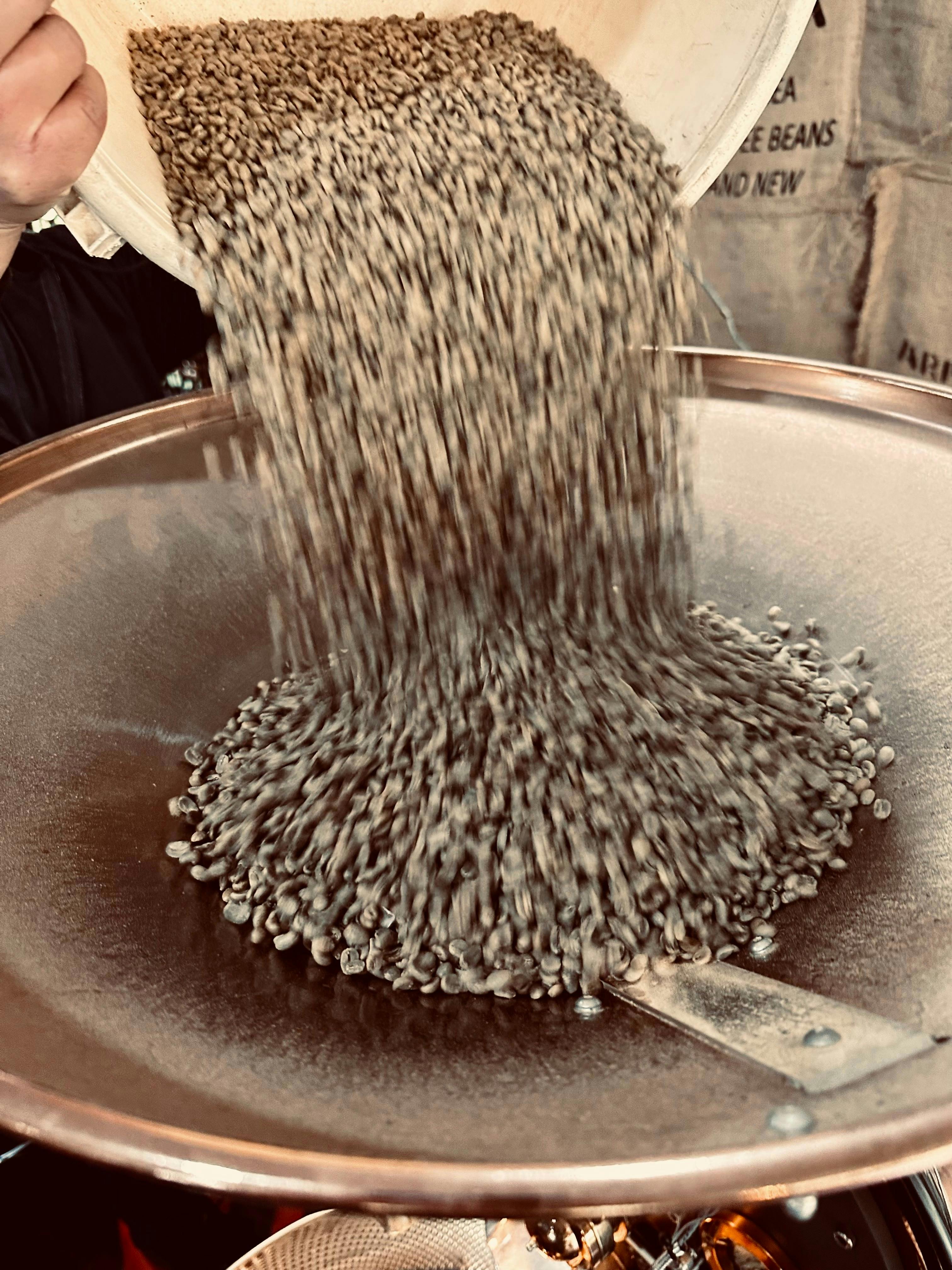 Freshly roasted coffee beans pouring from the roaster