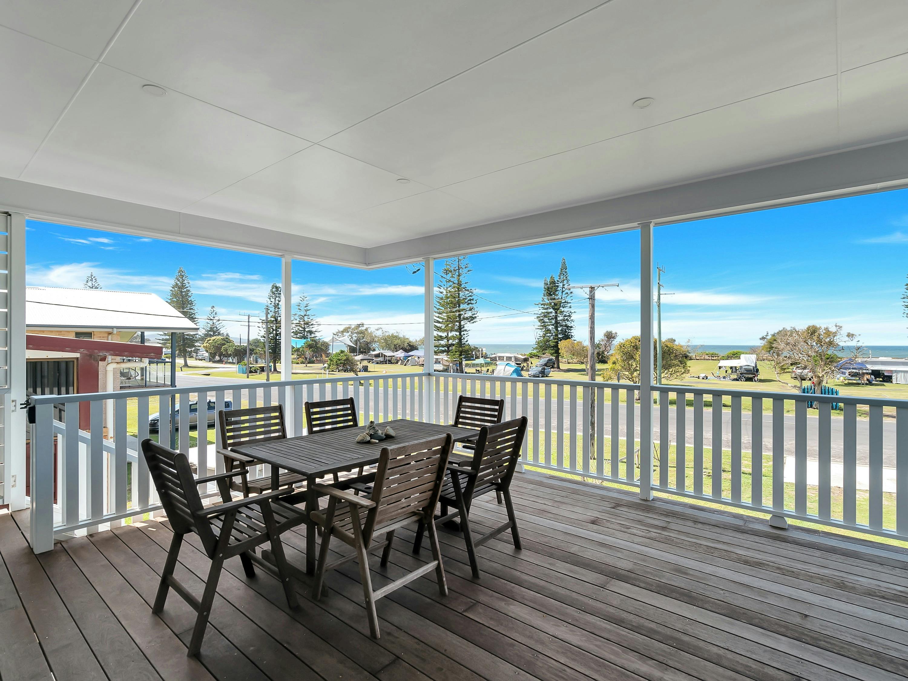 Photo of the front deck looking out to the caravan park and beach.
