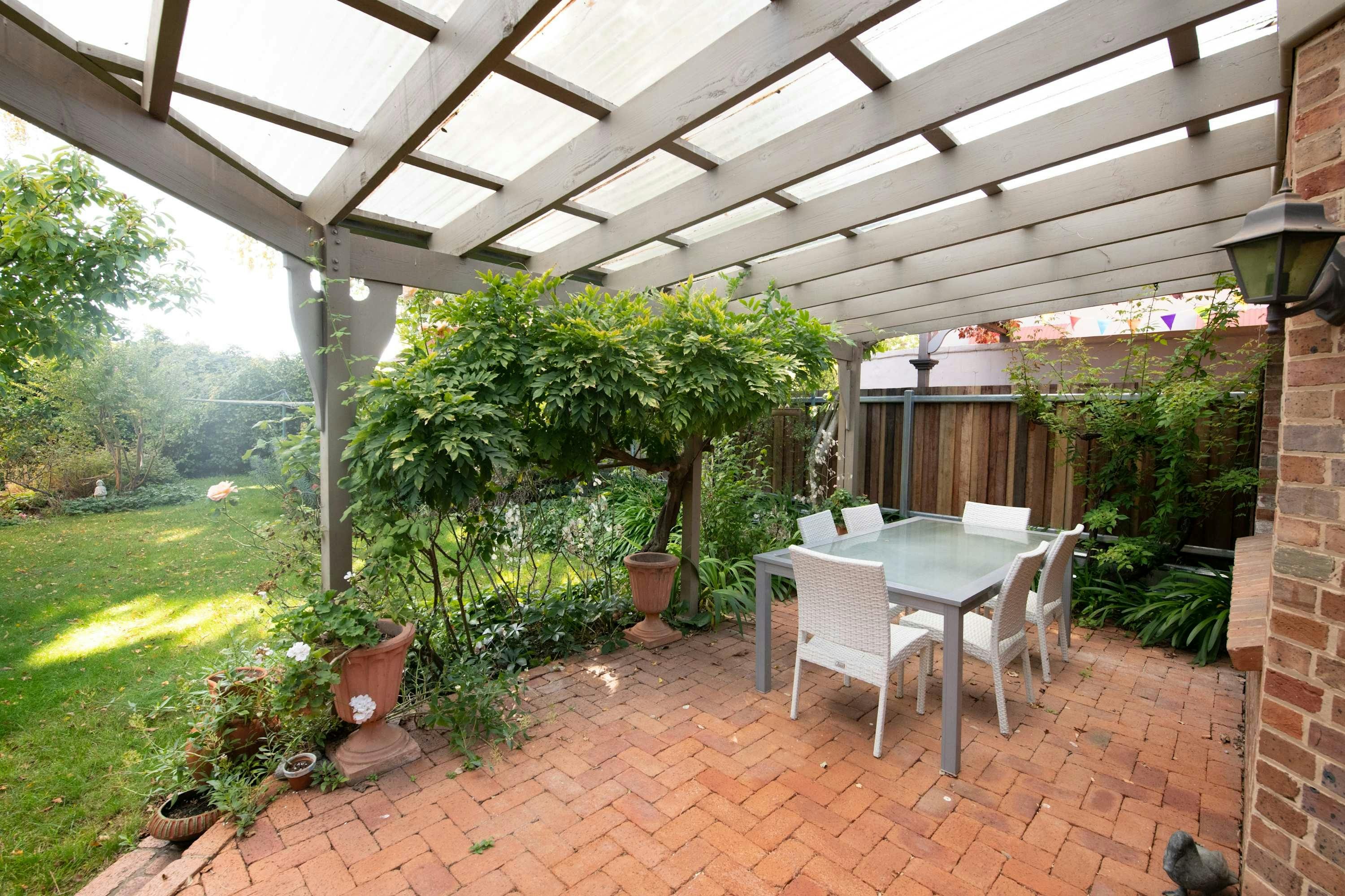 야외 식사 테이블이 있는 야외 지붕이 있는 파티오 공간