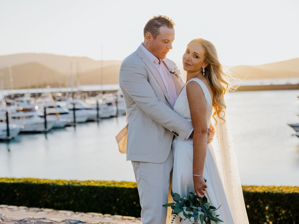 photo of bride and groom with Coral Sea Marina backdrop