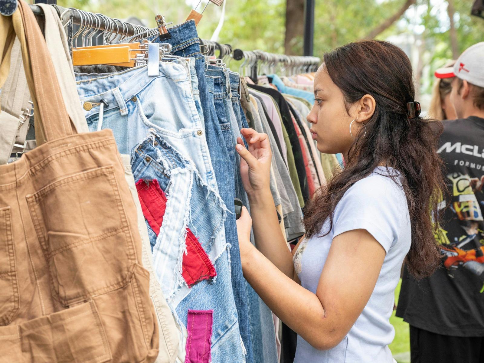 Girl shopping through vintage clothes.