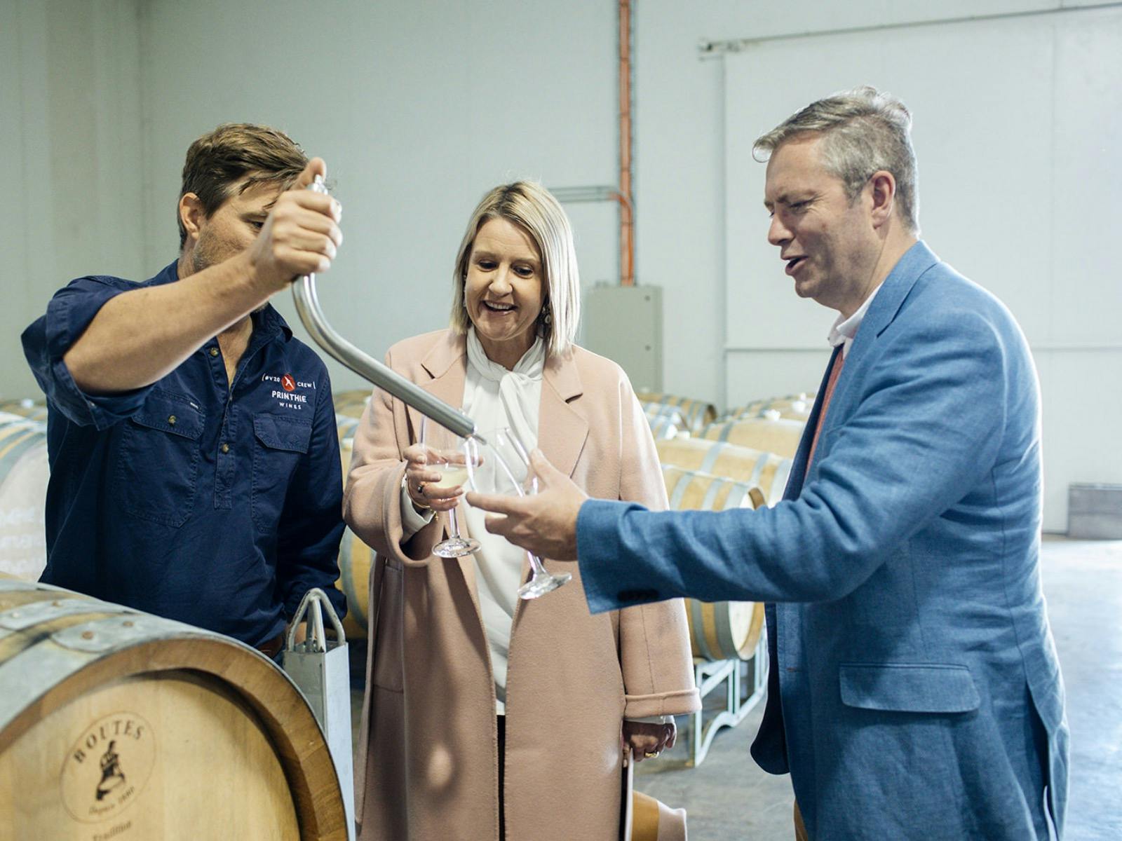 Couple enjoying tasting directly from wine barrel