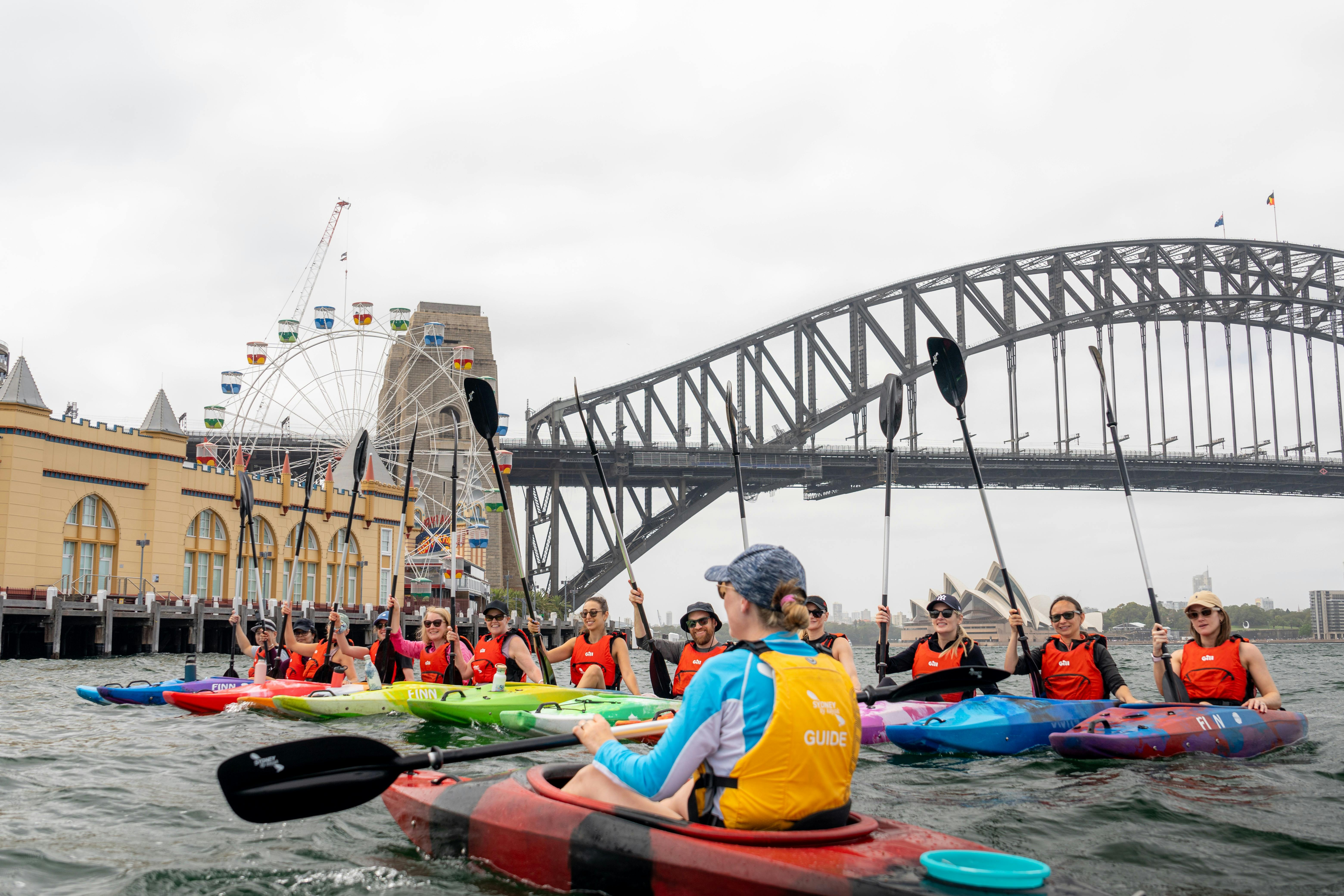 Group of kayakers in front of Luna Park and Sydney Harbour Bridge with Sydney By Kayak.