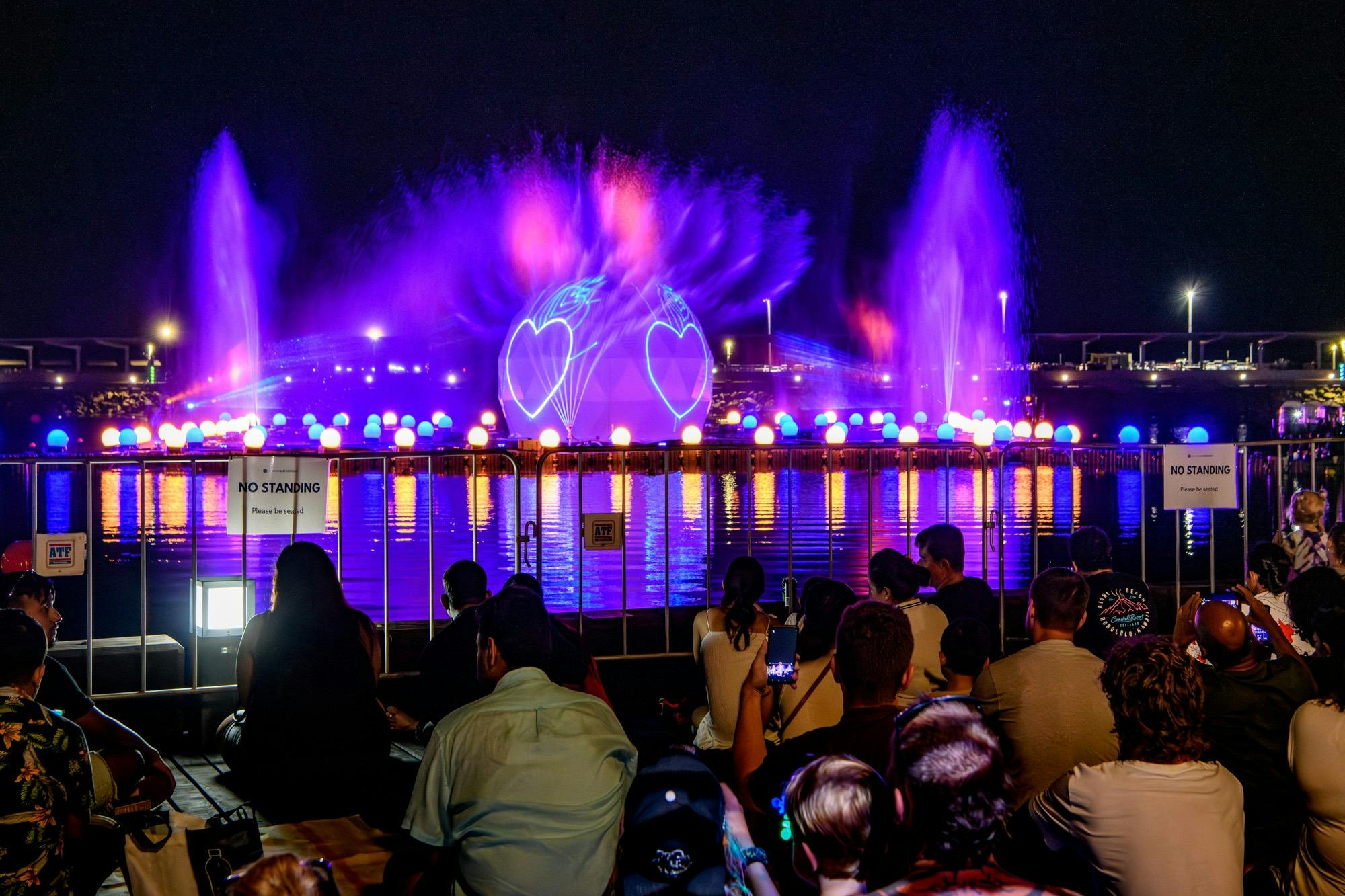 People enjoying the sound, water and light show in the Recreation Lagoon at the Waterfront.
