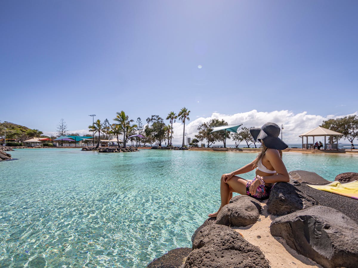 Girl sitting on edge of Settlement Cove Lagoon