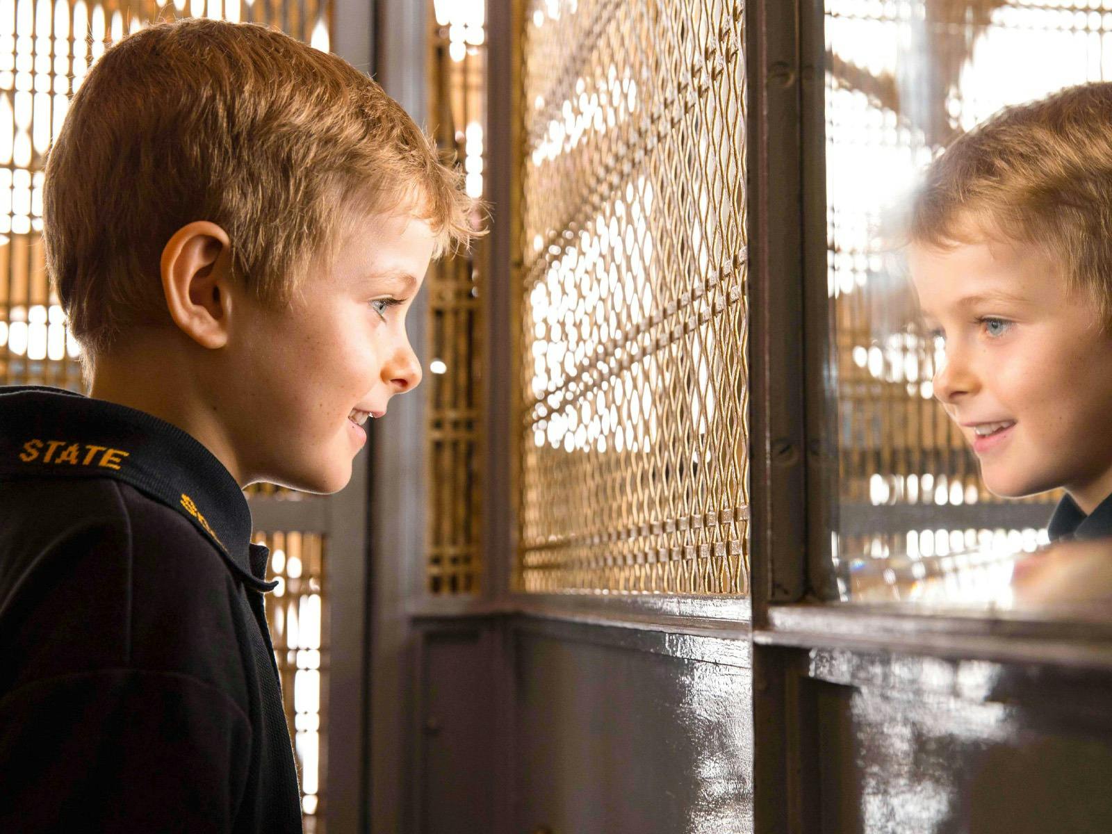 A child riding an old cage lift.