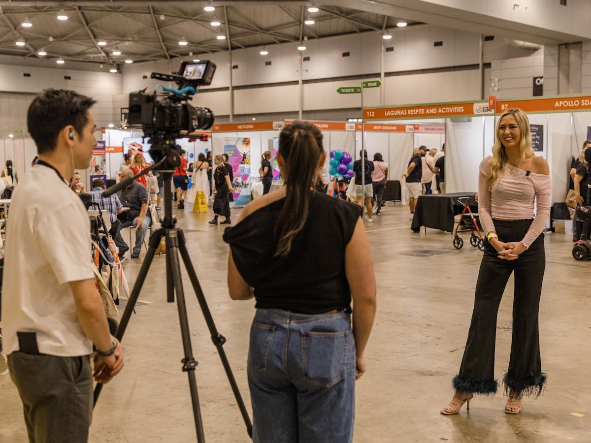Two staff members interviewing Ambassador Anja Christoffersen at Brisbane 2024