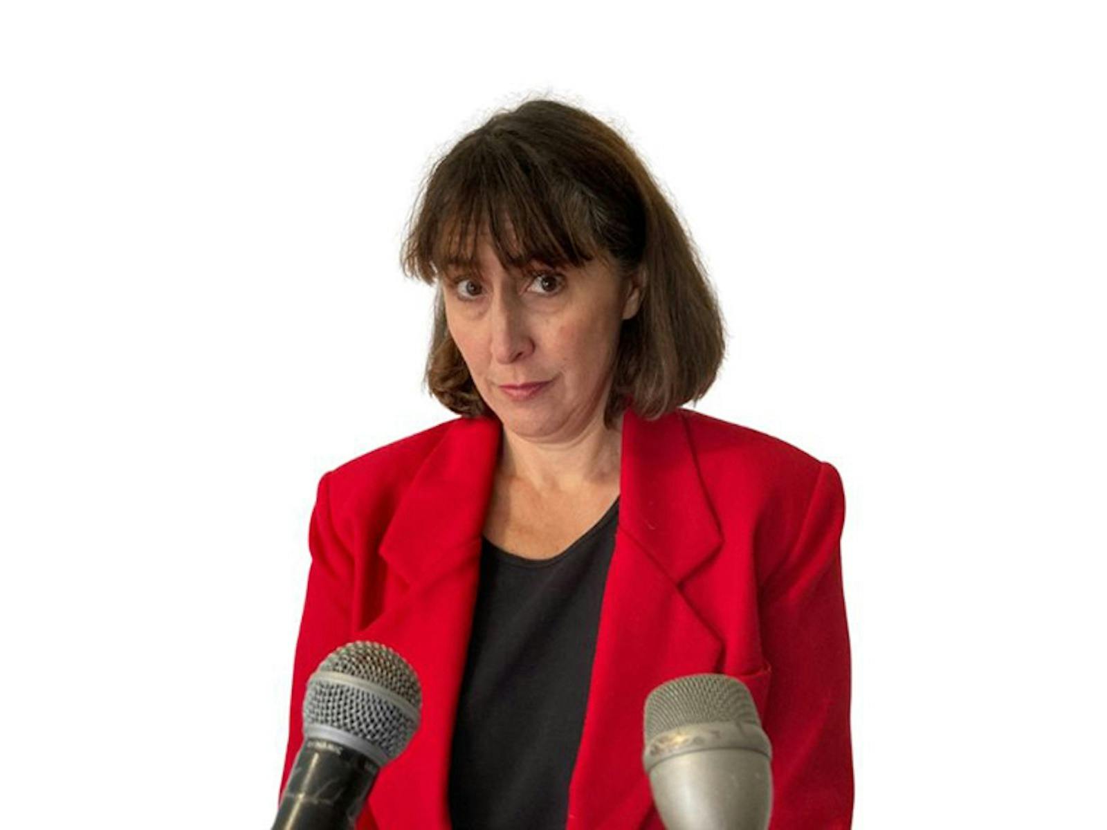 woman with short brown hair wearing a red blazer looking forward
