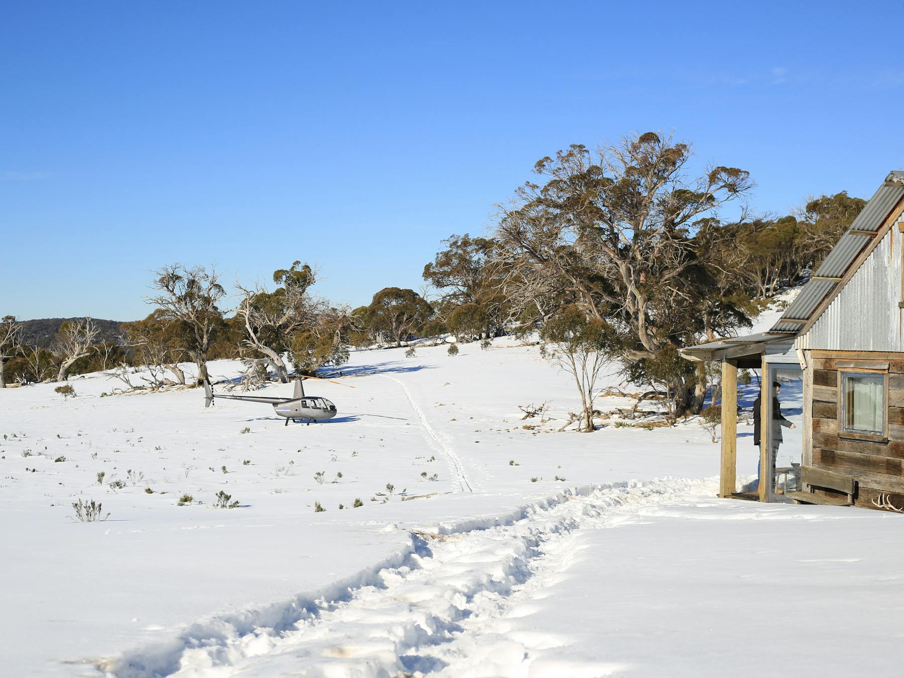 Robinson R44 landed on snow at private hut for Wilderness Picnic