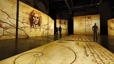 Visitors explore towering projections of Leonardo da Vinci’s sketches in an immersive gallery space.