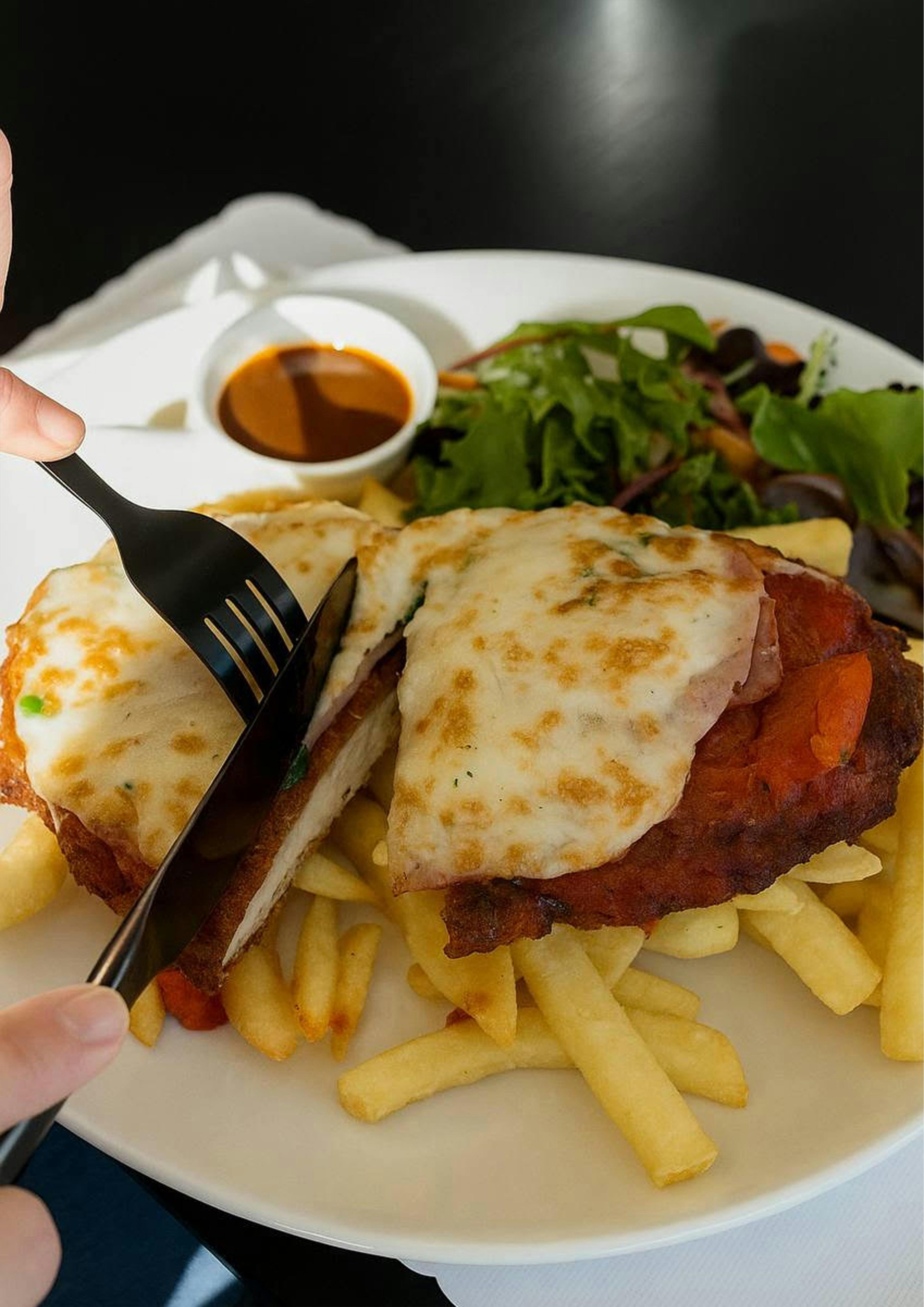 Chicken Schnitzel with golden fries and fresh salad at Esteria.
