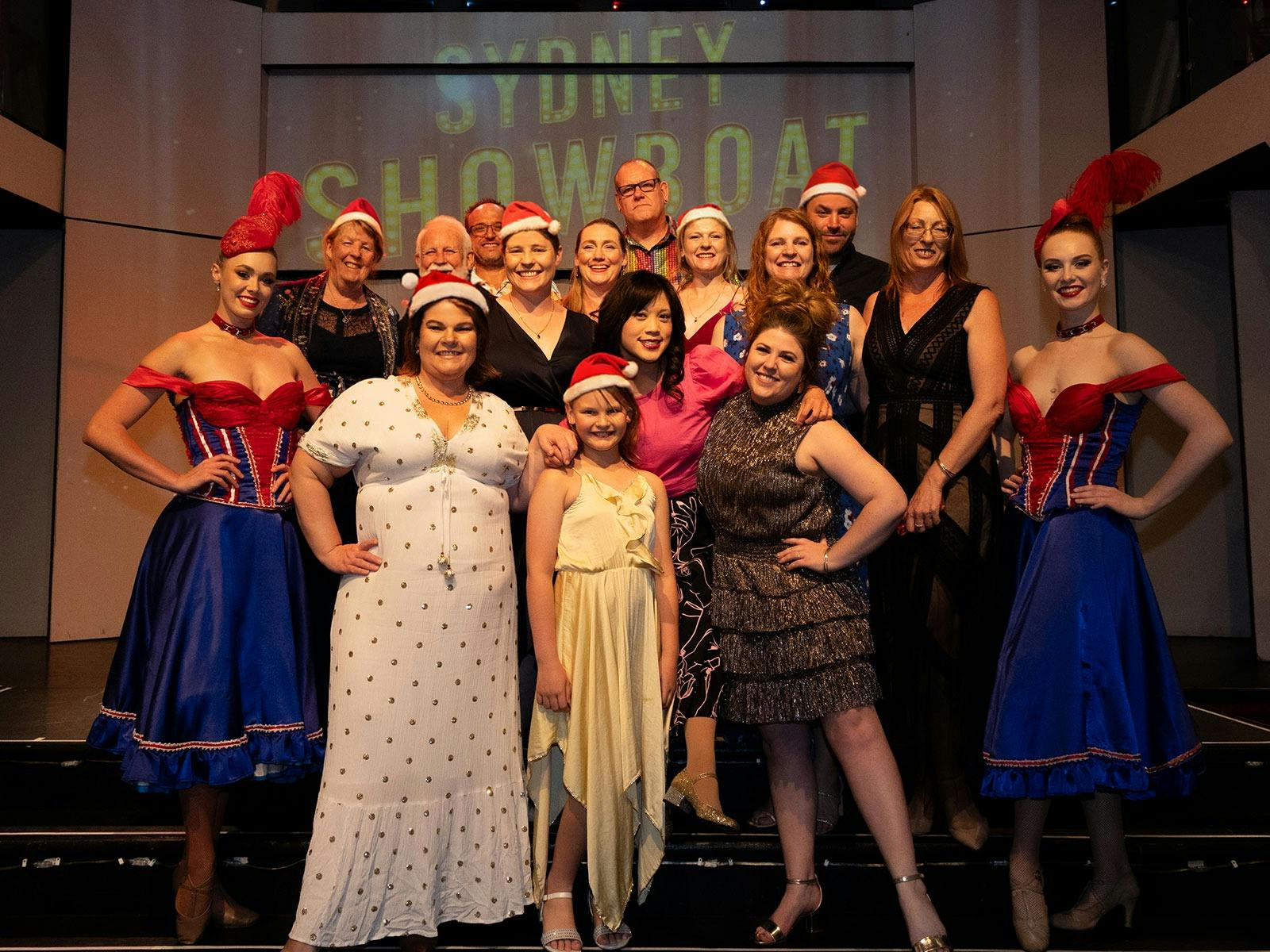 Guests posing with the fabulous follies of the Showboat’s Xmas party cruise