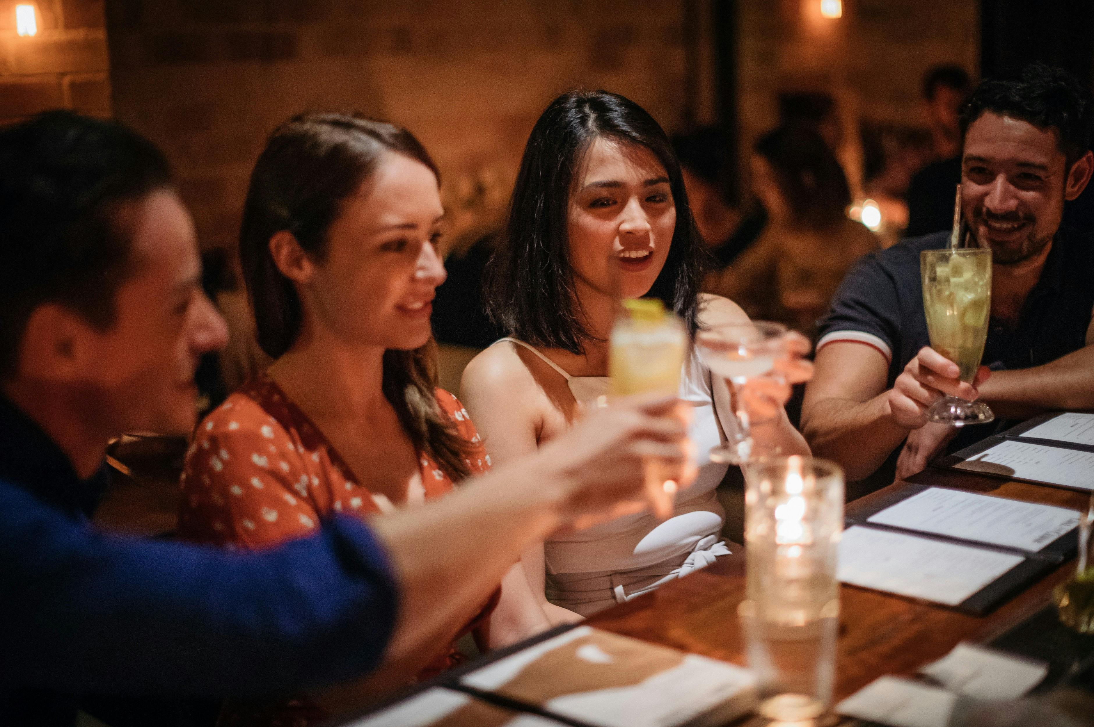 Friends enjoying cocktails at retro-chic bar Coal & Cedar in Newcastle
