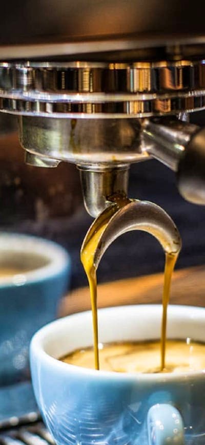 Coffee being brewed into a pale blue coffee cup