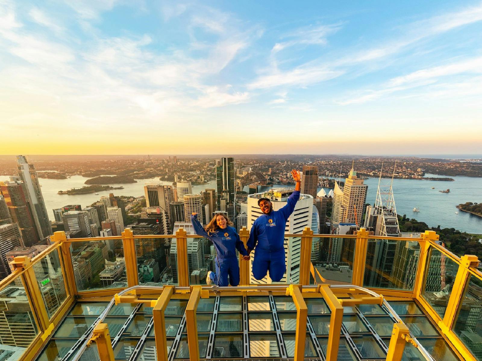 A couple jumping for joy on SKYWALK at the Sydney Tower Eye