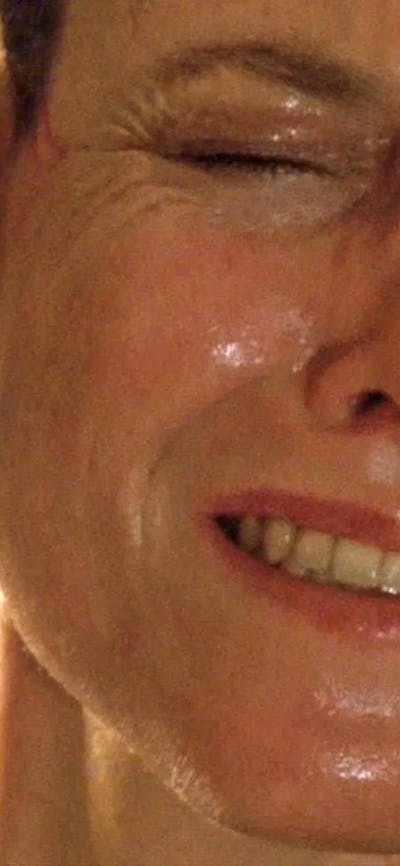 Woman looking scared on right with alien figure with dripping teeth threatening her