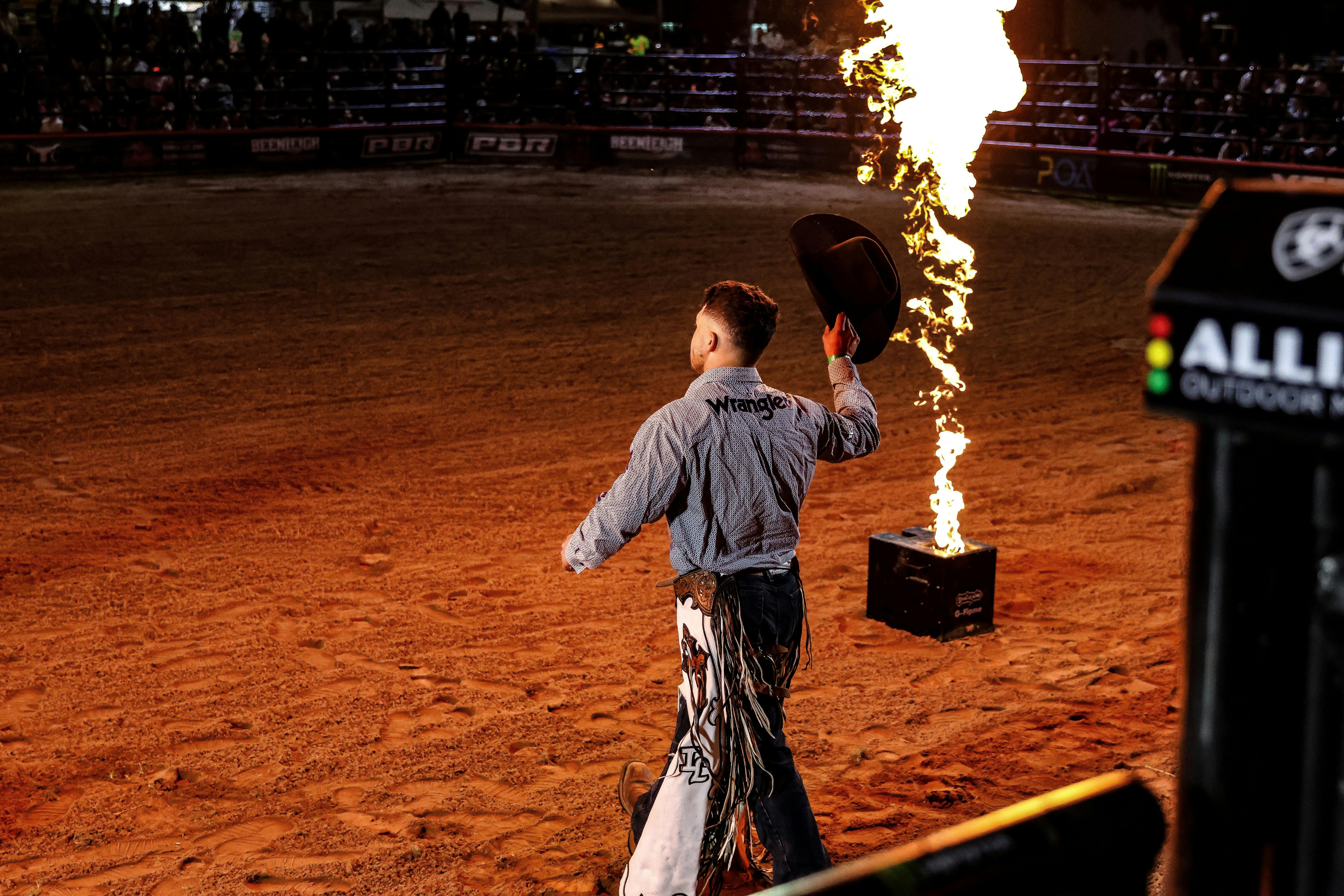 PBR cowboy enters arena during show opening.