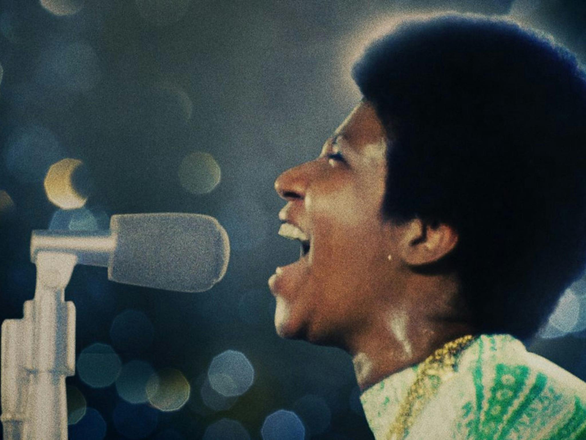 Still from Amazing Grace showing a woman singing into a microphone