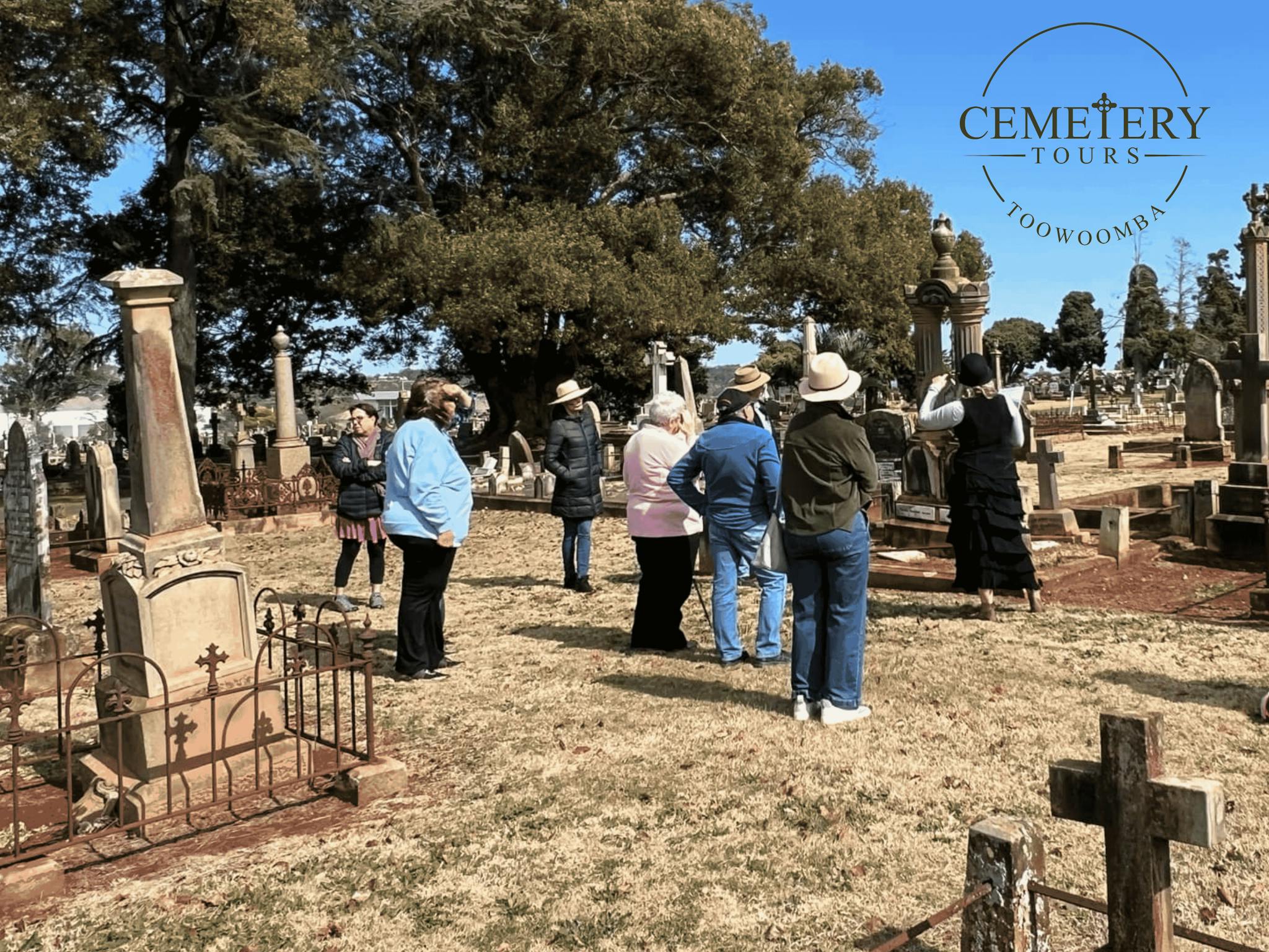 A group of people, backs to camera, looking at graves