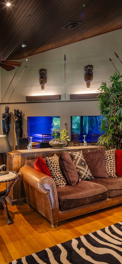 Lounge room surrounded by 200,000L aquarium. African inspired styling.