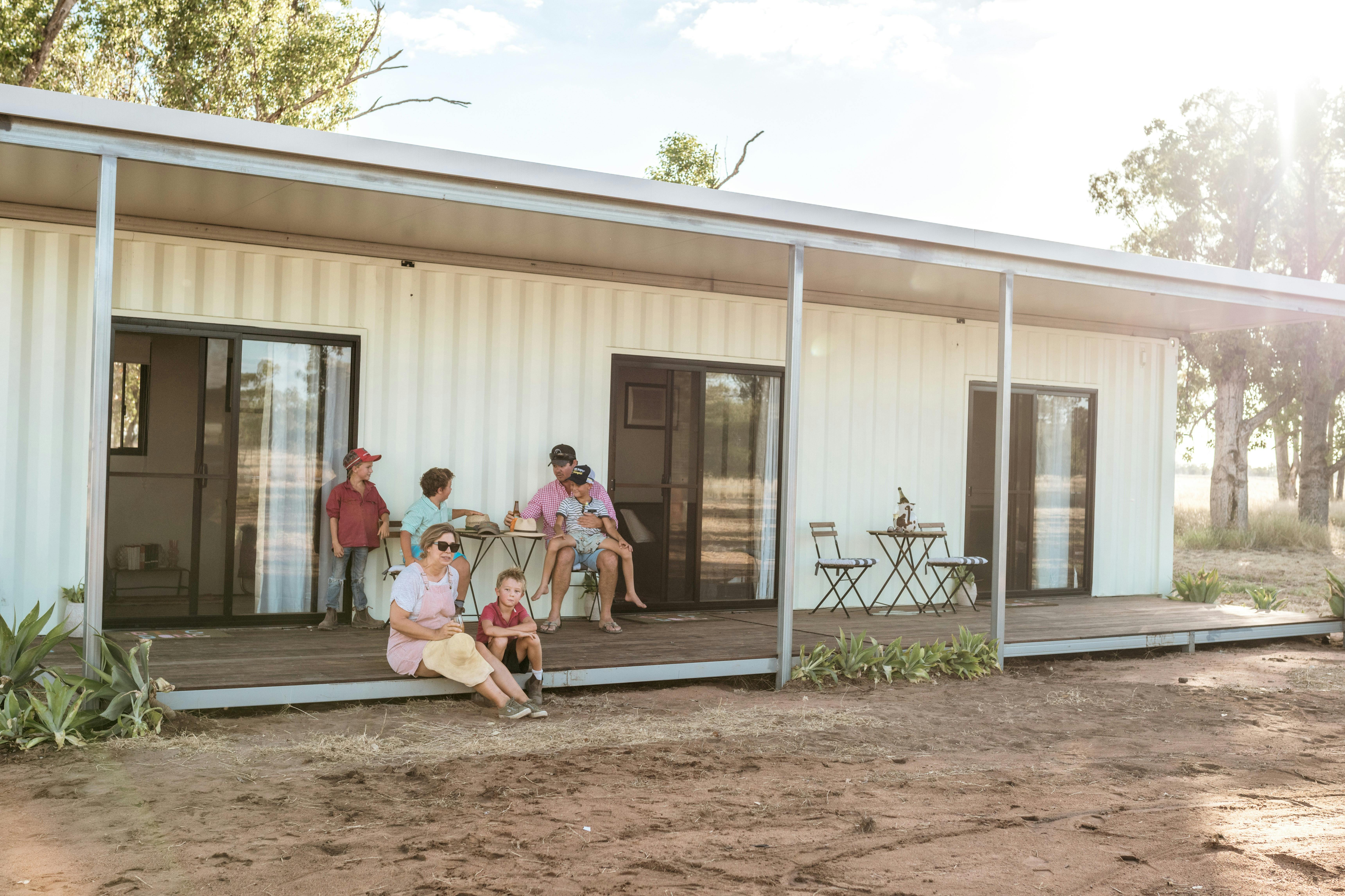 A family enjoying the deck of the cabin accommodation at Gilgooma farm stay with a view