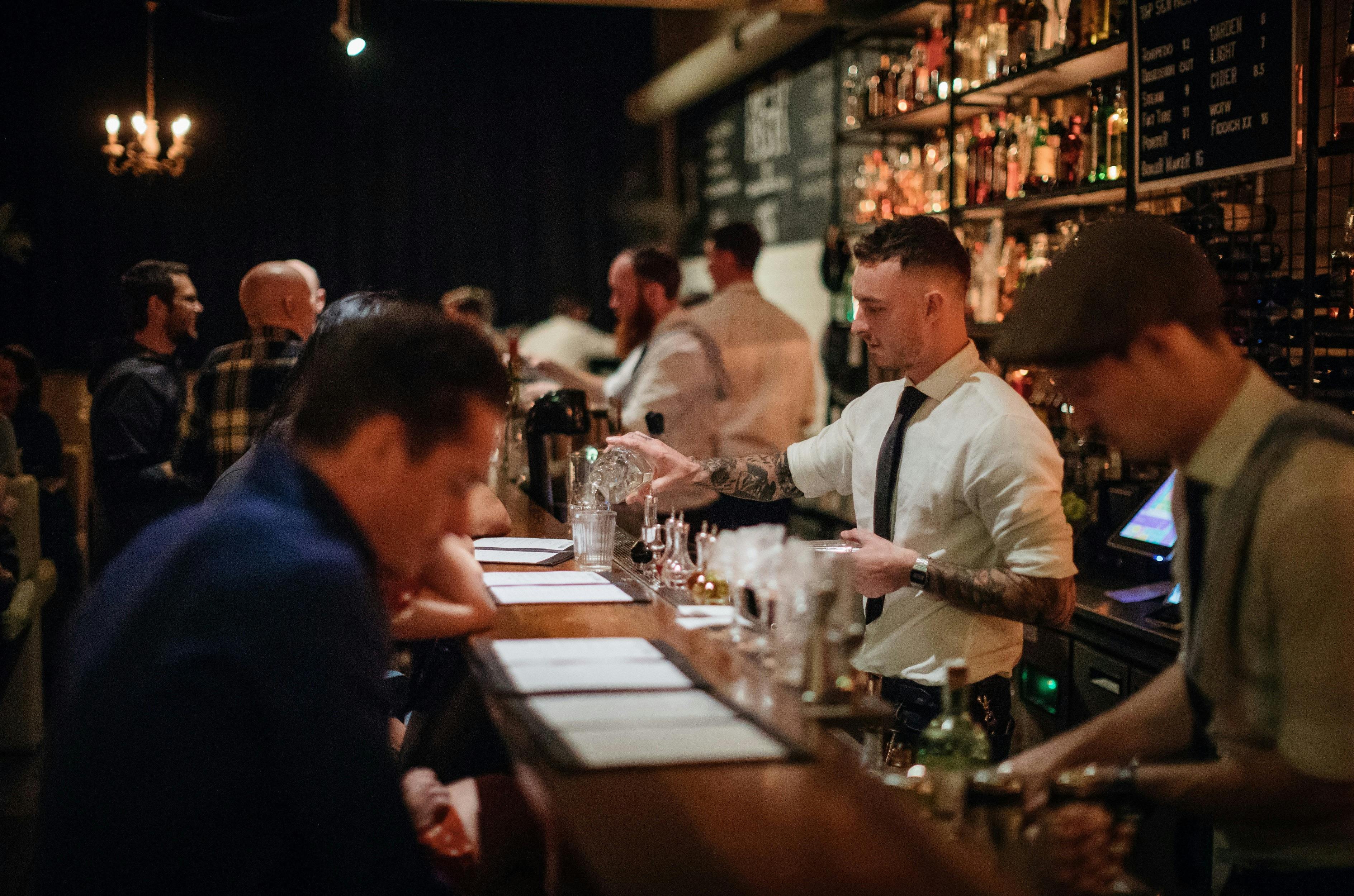 Bartender pouring cocktails for patrons at retro-chic bar Coal & Cedar in Newcastle