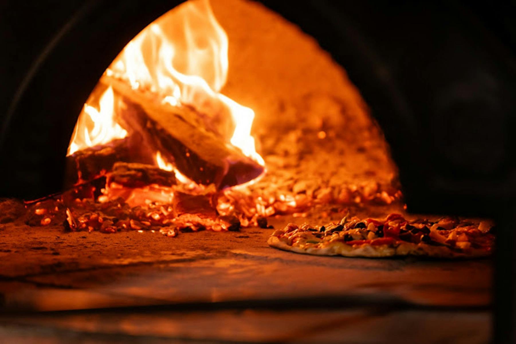 Pizza cooking in woodfired oven