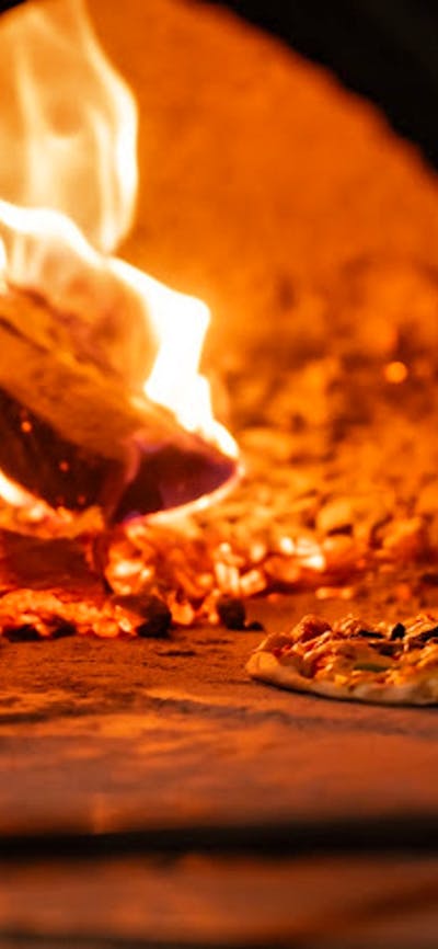 Pizza cooking in woodfired oven