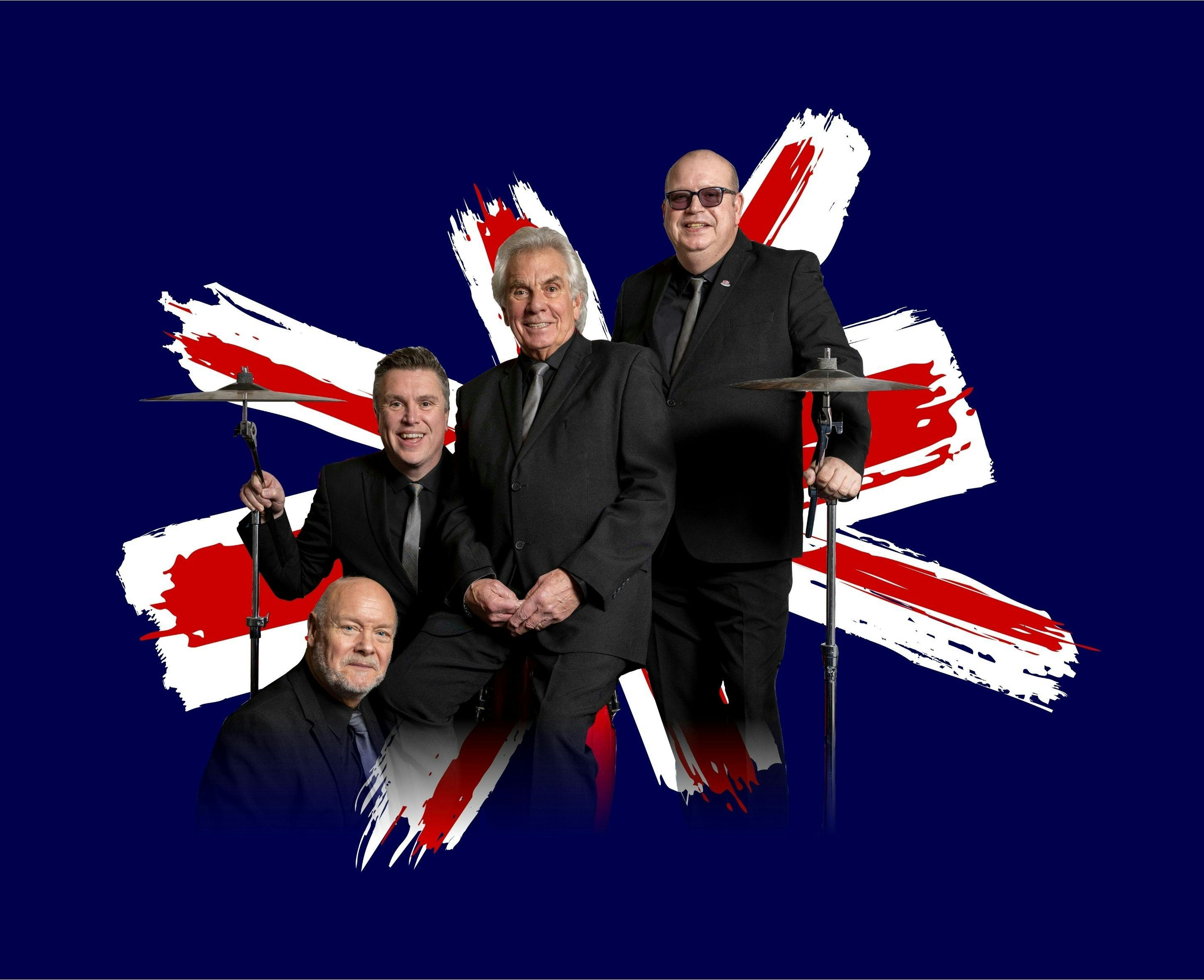 Members of Herman's Hermits pose, wearing black suits, infront of the Union Jack.