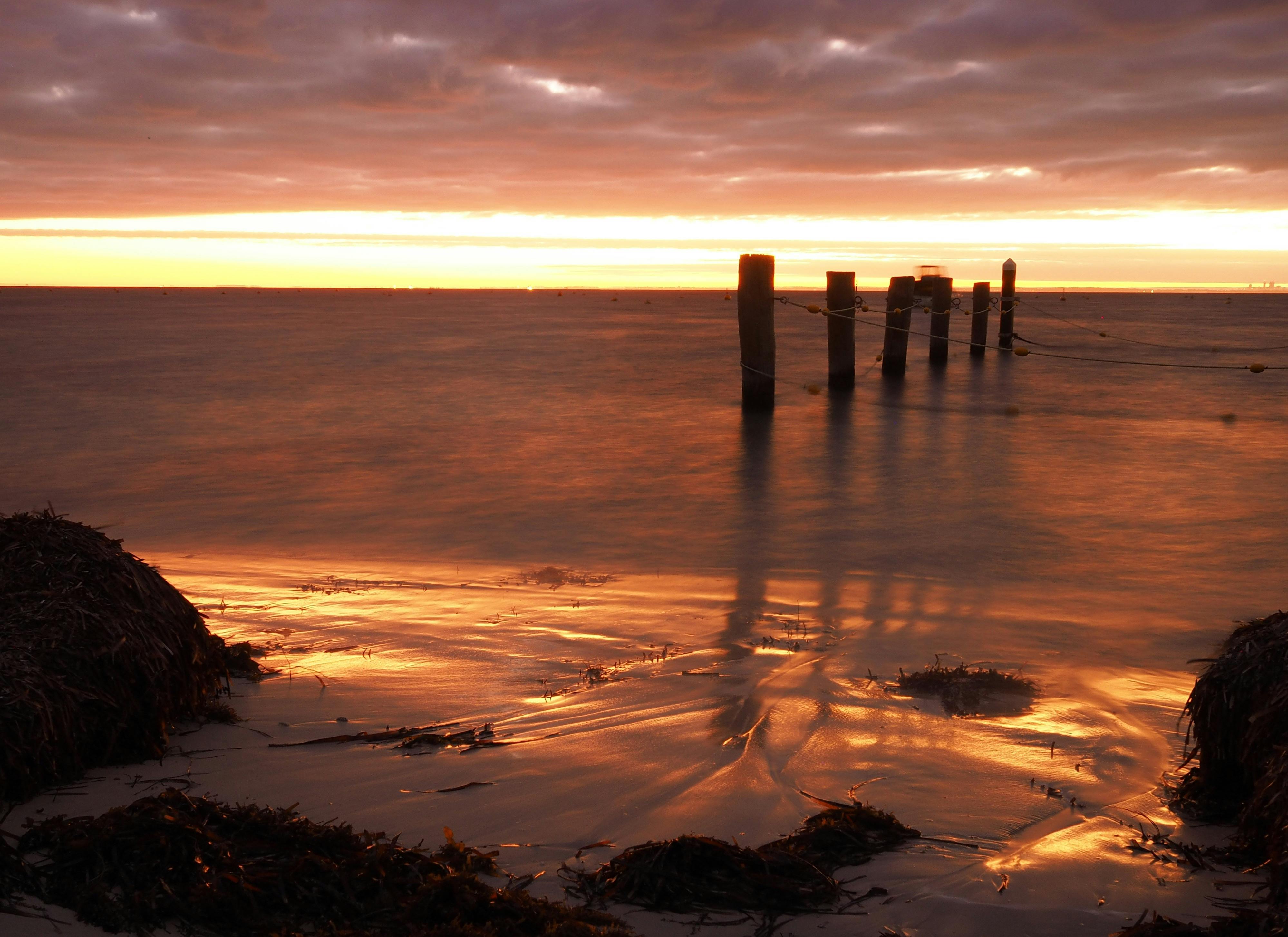 Thompson Bay bathed in soft orange light of the rising sun