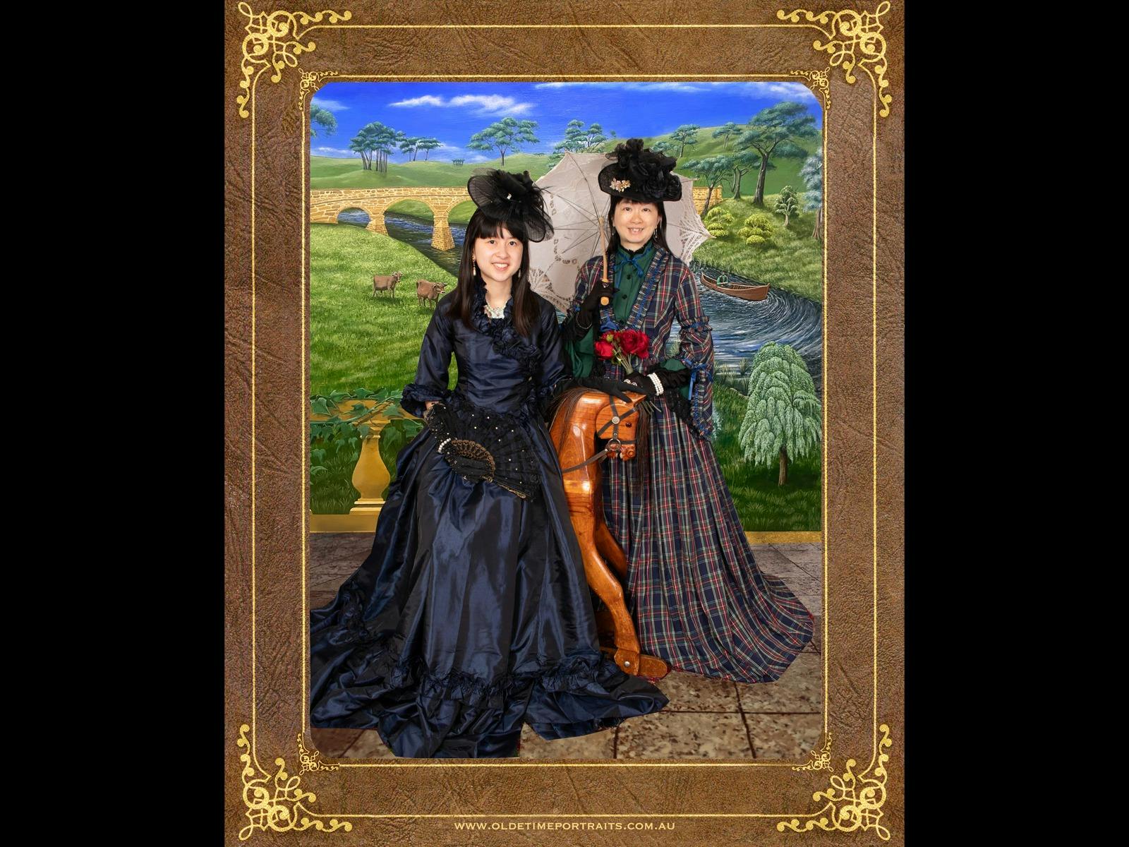 2 ladies in victorian costume on rocking horse, backdrop Richmond Bridge Tasmania