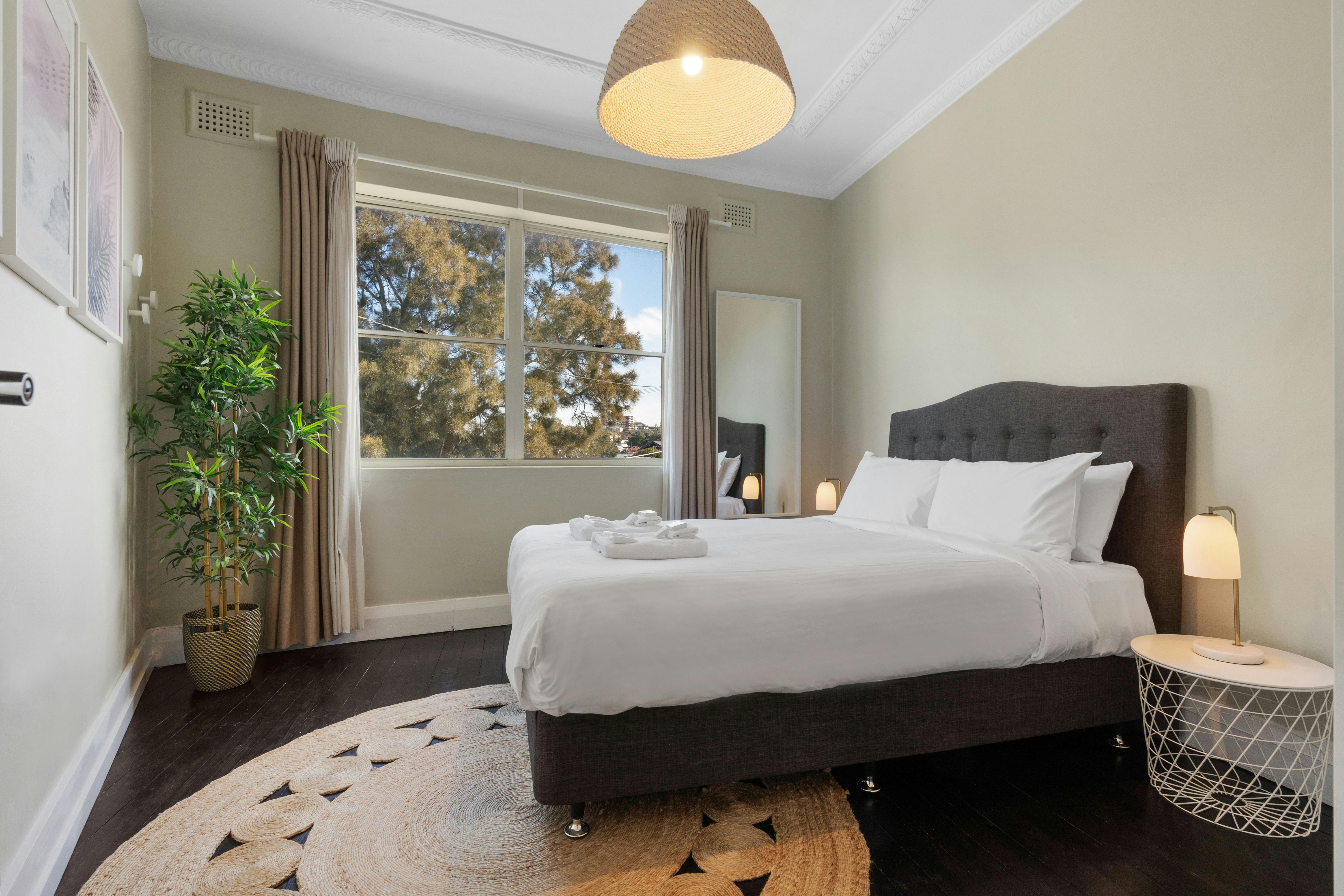 Modern bedroom with stylish decor and a cozy bed with fresh linens.